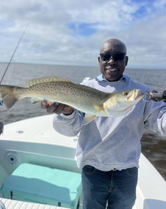 A person fishing for a spotted weakfish on Fort Myers Beach