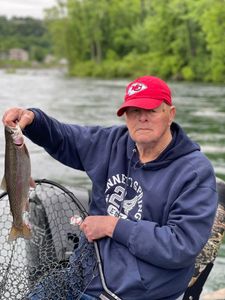 A fisherman holding a rainbow trout in MO