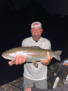 A person fishing for a rainbow trout in Branson