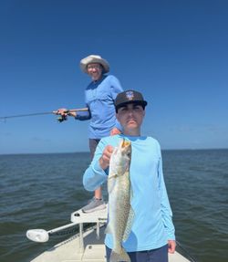 A fisherman holding a spotted weakfish caught while fishing in FL