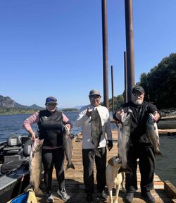 Three anglers displaying fresh caught Chinook and Coho salmon on dock in Portland OR