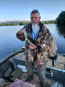 Angler holding freshly caught bass on fishing boat at Forest Inn PA