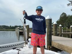 Speckled trout caught fishing in Gulf Shores AL displayed on dock with fishing pliers