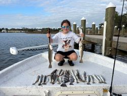 Successful fishing trip in Gulf Shores AL showing speckled trout and black drum catch on boat deck