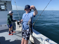 A fisherman holds a large sea bass in Neptune City