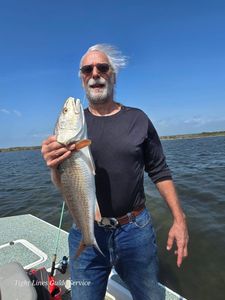 Angler holding caught redfish on fishing boat at Point Comfort TX