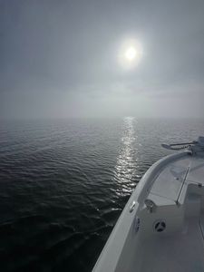 Fishing boat on calm water with sun reflecting off surface in Port Arthur TX