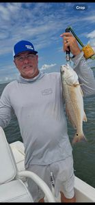Angler holding caught redfish on fishing boat in Port Arthur TX waters