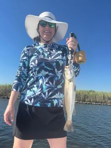 Angler holding caught speckled trout while fishing in Port Arthur TX waters
