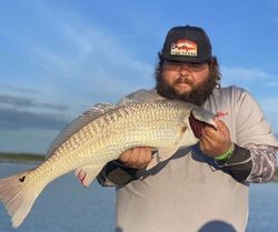 Lone angler fishing in Corpus Christi with a 20-inch catch