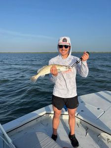 A person fishing for a spotted weakfish in TX