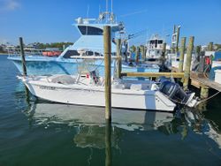 Fishing boats docked at marina in Gulf Shores AL with wooden pier posts