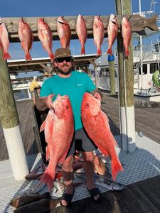 Red snapper and silk snapper catch displayed on fishing dock in Orange Beach AL