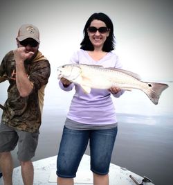 A pair of people fishing on the shore in TX
