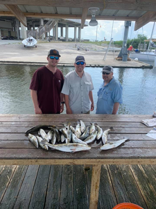 A group of three people fishing in the waters of Pass Christian