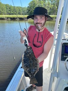 A fisherman holding a European flounder, a 14-inch fish, in NC