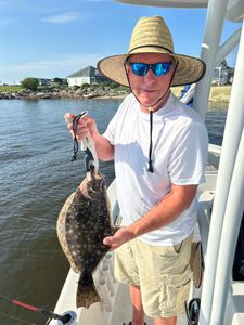 A fisherman catches a summer flounder in North Carolina
