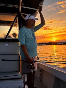 Fishing boat at sunset in Wells Harbor Maine with fishing rod and scenic harbor view