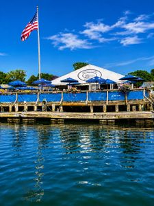 Wells Harbor Maine waterfront fishing dock with blue umbrellas and American flag