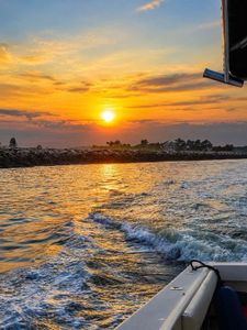 Fishing boat wake at sunset in Wells Harbor Maine waters