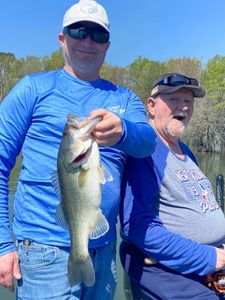 Two anglers displaying a large bass caught while fishing in North Myrtle Beach SC