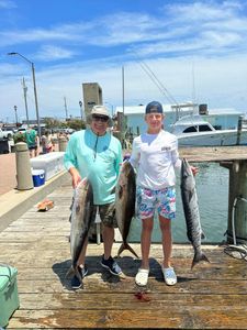 Successful fishing trip in Morehead City NC showing caught Great Barracuda and Greater Amberjack on marina dock