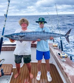 Two anglers displaying a large wahoo fish caught during deep sea fishing trip in Morehead City NC