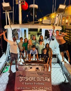 Charter fishing boat Offshore Outlaw docked at night in Morehead City NC with fishing equipment visible