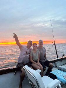 Fishing boat on ocean water at sunset in Morehead City NC with fishing rods