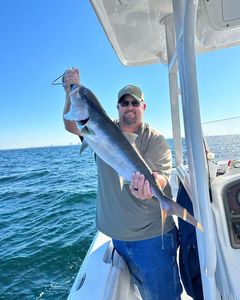 Angler reeling in a 27-inch fish at Panama City Beach