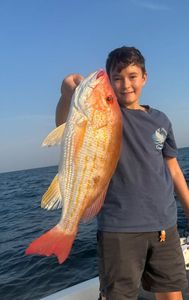 Angler standing in Pensacola with fishing rod and reel