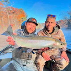Angler with a large rainbow trout caught while fishing in MI