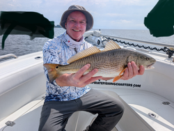 Reeling in a big redfish on a clearing afternoon with storms on the horizon