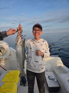 Angler holding freshly caught fish on fishing boat in Port Washington WI