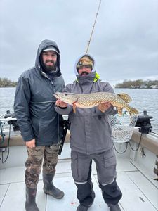 Two anglers holding a Northern Pike catch on fishing boat in Ogdensburg NY