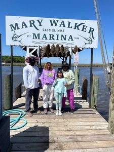 Four people fishing in the ocean at Ocean Springs