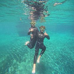 Two snorkelers swimming underwater in clear turquoise water in Crystal River FL
