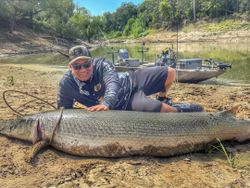 Large alligator gar caught fishing in Cayuga TX with boat and fishing equipment in background