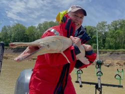 Angler holding caught alligator gar on fishing boat in Cayuga TX