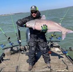 Angler holding a 33-inch catch during a fishing trip in Cayuga