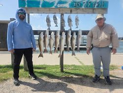 Two anglers holding their catch in Port Aransas