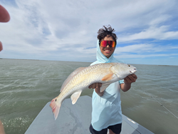 Reeling in a feisty Redfish in the sunny Port Aransas waters!
