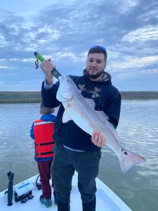 A person holds a 25-inch redfish caught while fishing in TX.