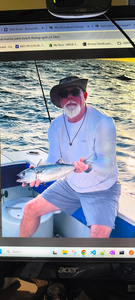 Angler holding caught fish on fishing boat in open water