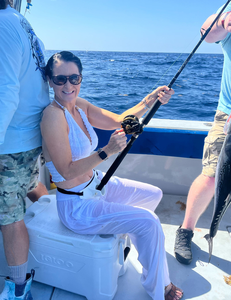 Deep sea fishing with rod and reel on boat deck over blue ocean waters