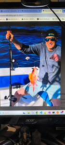 Fishing rod with caught fish on boat deck over blue ocean water