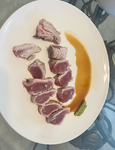 Fresh caught tuna sliced and plated with sauce, showing the results of a successful fishing trip
