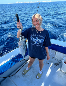 Little tunny catch displayed on fishing boat deck over blue ocean water