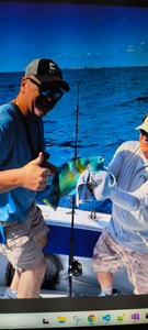 Fishing charter with colorful mahi-mahi catch on boat deck in blue ocean waters
