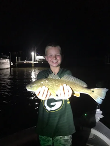 Night fishing catch showing freshly caught redfish being held up